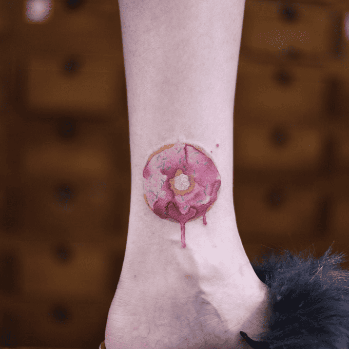 Watercolor pink-frosted donut tattoo