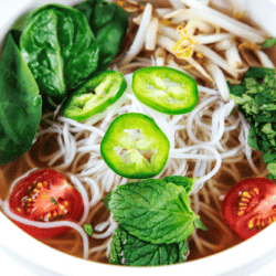 A rich broth full of tender chicken, scallions, Asian-inspired spices, and topped with bean sprouts, spinach, mint, cilantro, tomatoes, and spicy jalapeno, this pho made in a pressure cooker will rock your world.